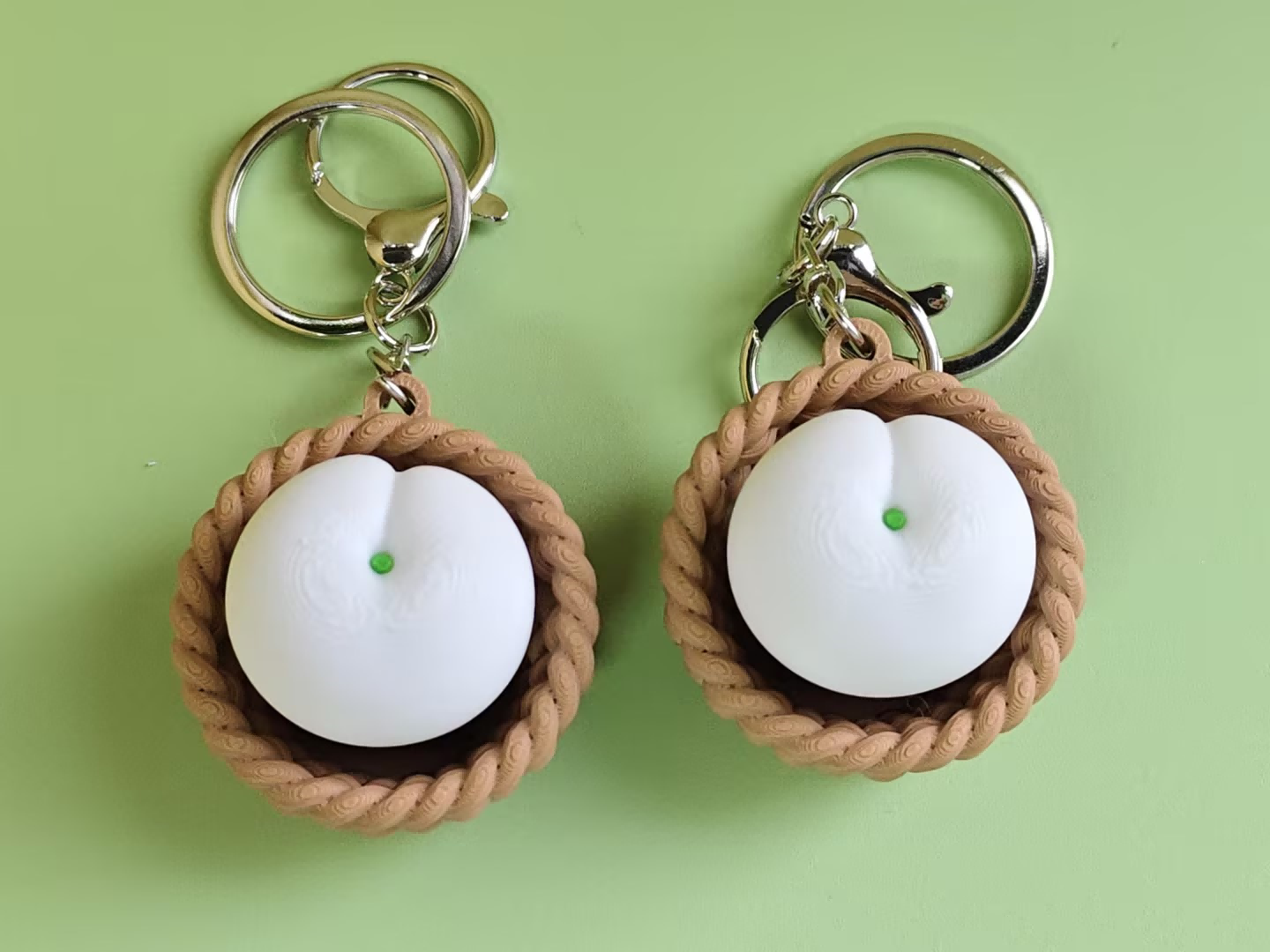 3D printed white peach push-toy keychain